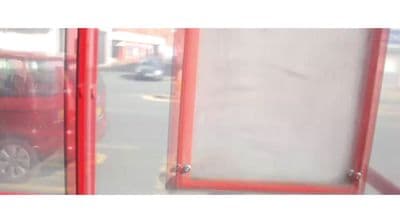 a red van is parked in front of a glass door