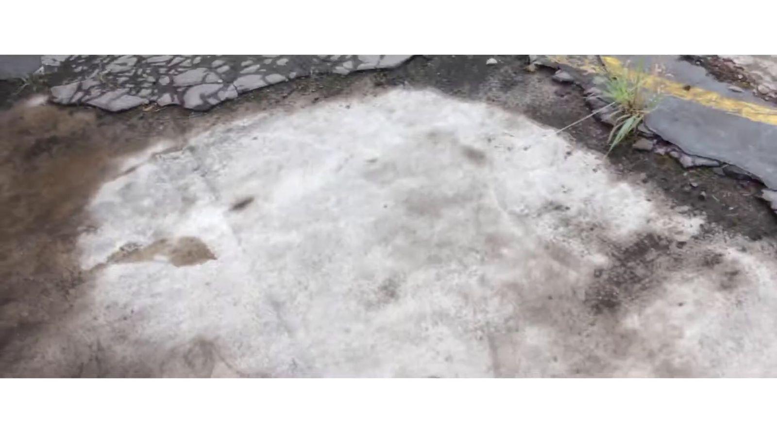 a patch of snow on the ground next to a road