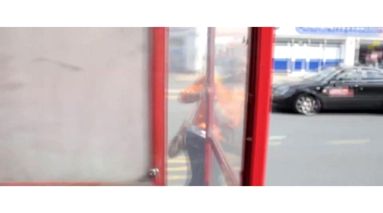 a car is parked in front of a bus stop