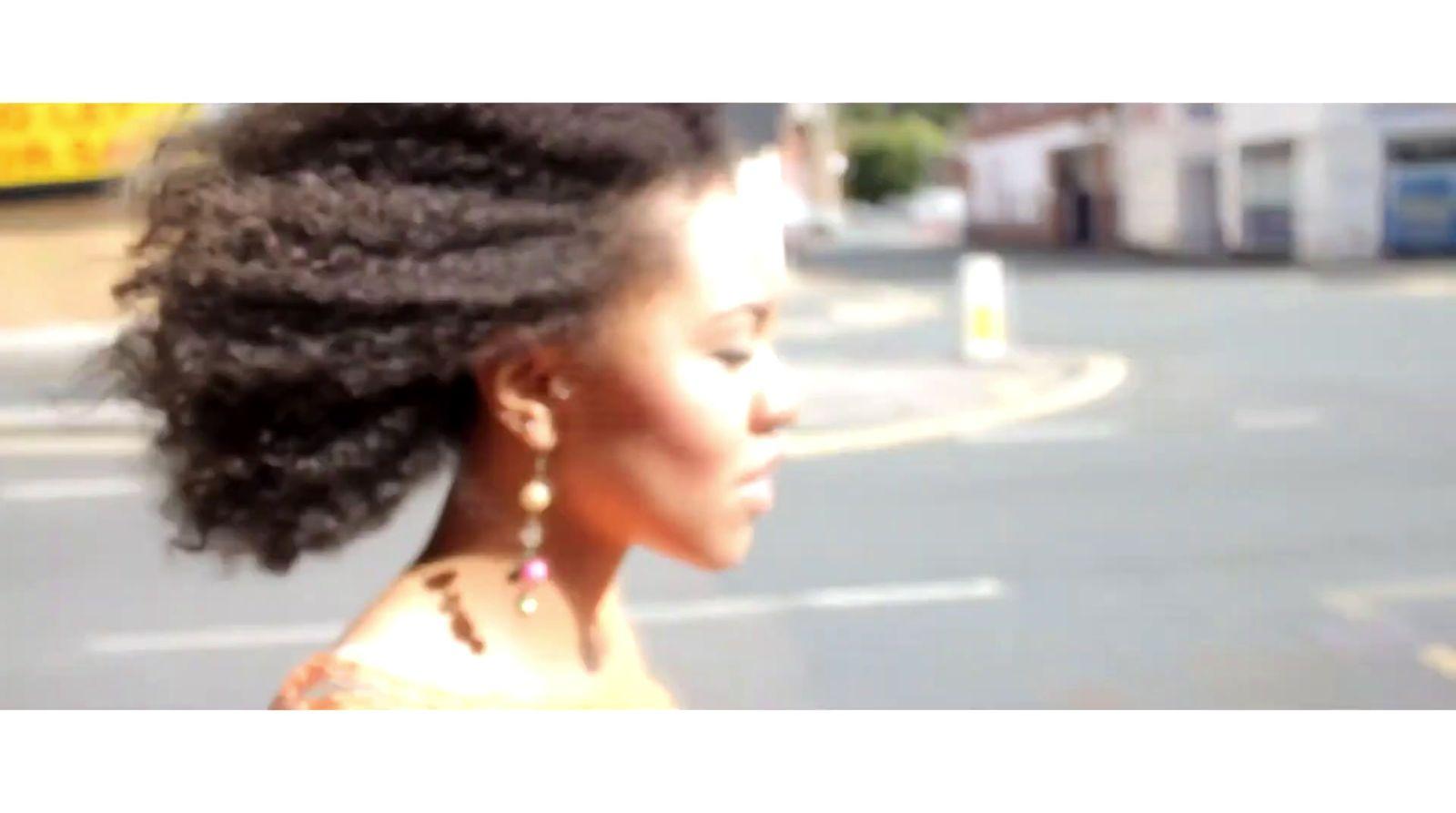 a woman walking down a street next to a traffic light