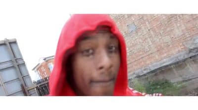 a man in a red hoodie looking at the camera