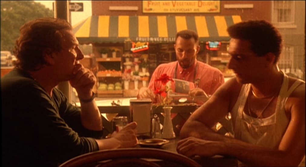 three men sitting at a table talking to each other