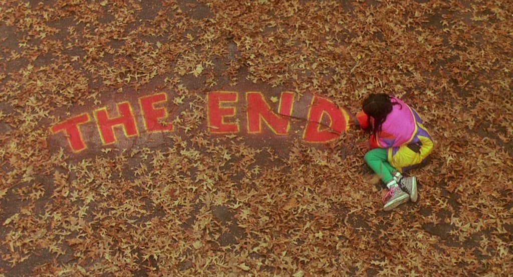 a person writing the end on the ground
