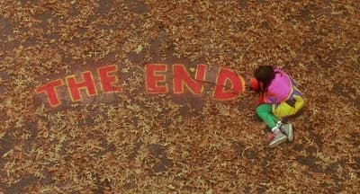 a person writing the end on the ground