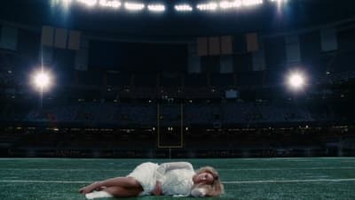 a woman laying on the ground in a stadium