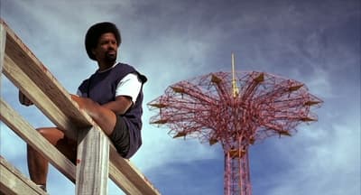 a man sitting on a rail next to a tall tower