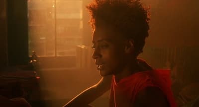 a woman in a red vest sitting in front of a window