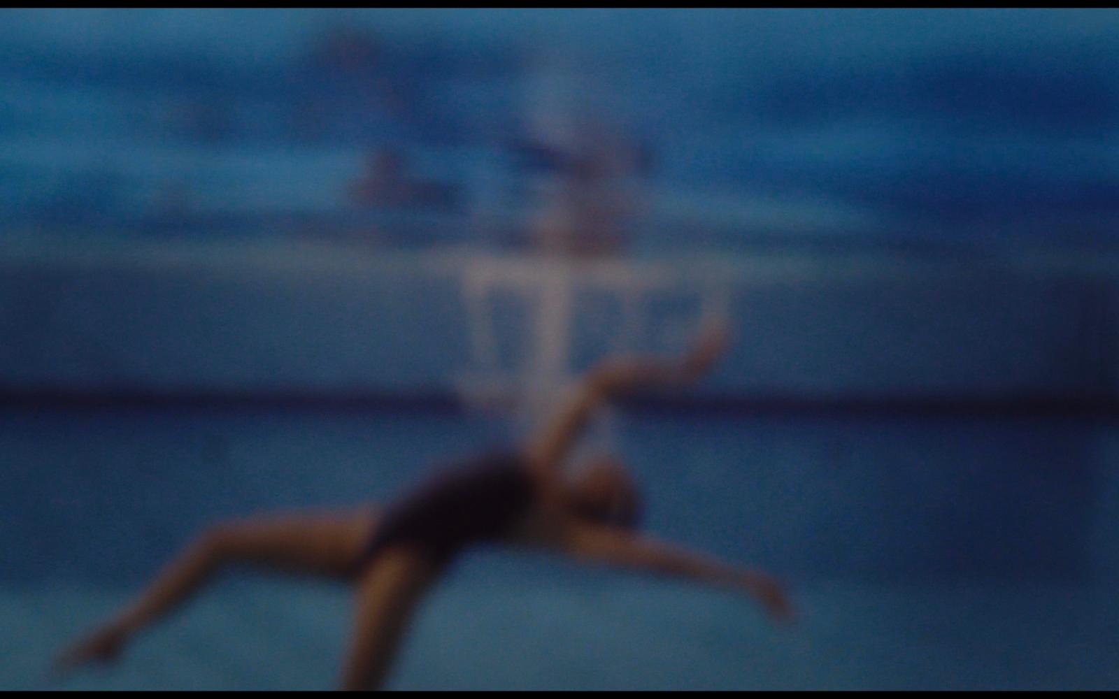 a blurry photo of a person jumping in the air with a frisbee