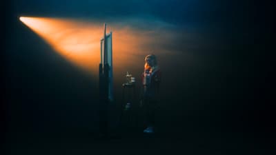 a woman standing in front of a light in the dark
