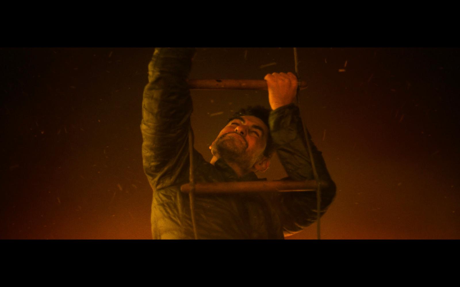 a man holding onto a pole in the air