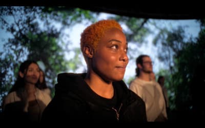 a woman with red hair standing in front of a group of people