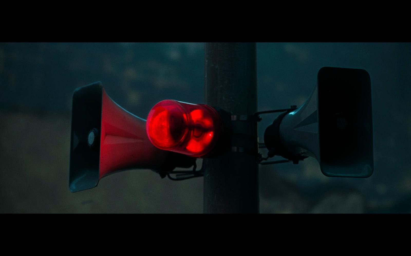 a red traffic light sitting on top of a metal pole