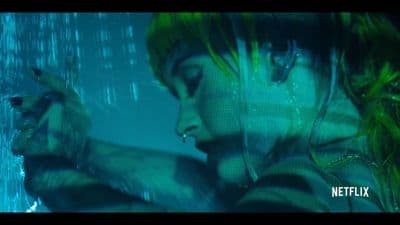a woman with green hair holding a gun