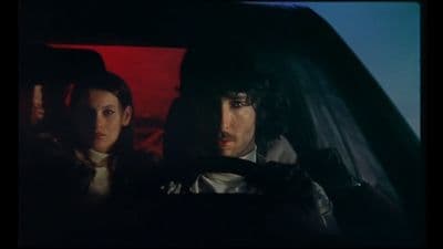 a man and a woman sitting in a car