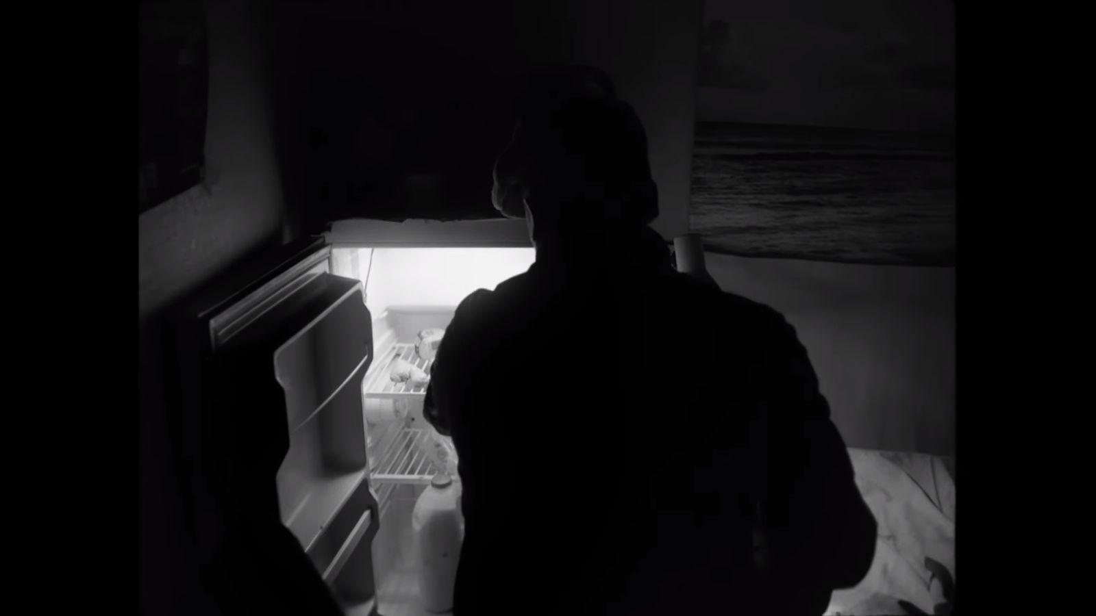 a person standing in front of an open refrigerator