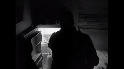 a person standing in front of an open refrigerator