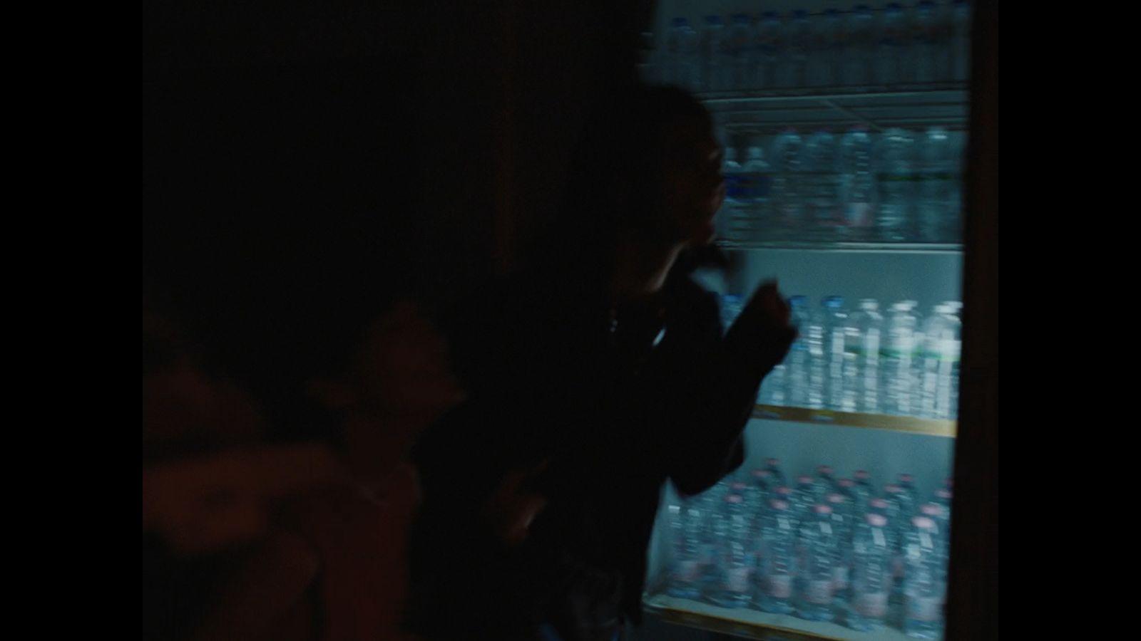 a man standing in front of a refrigerator filled with water