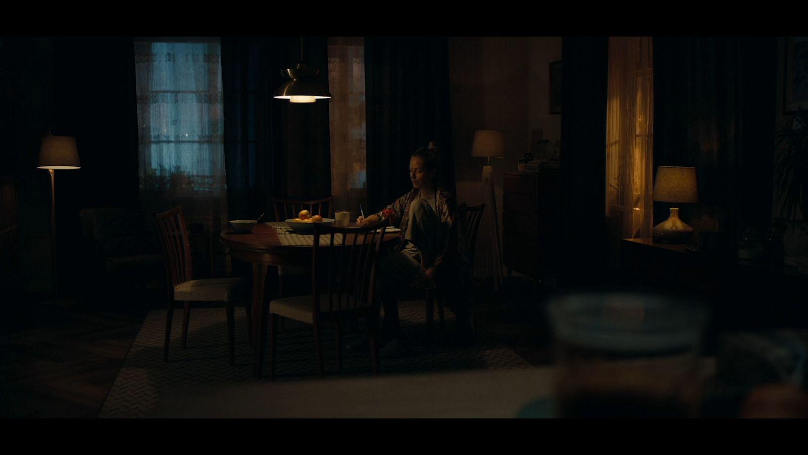 a man sitting at a table in a dark room