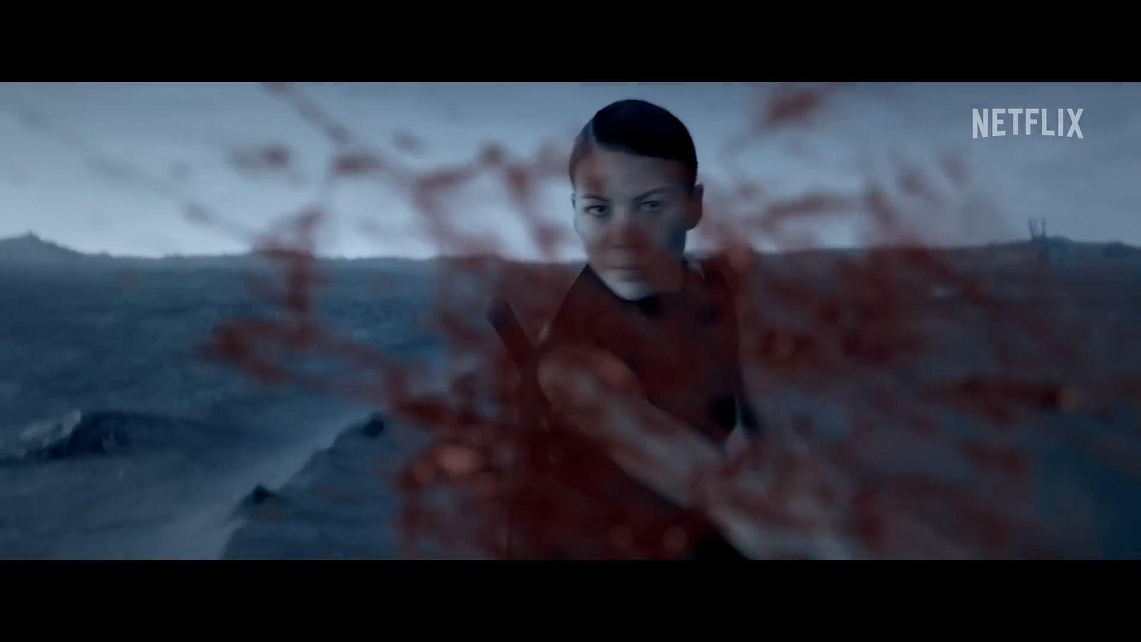 a woman standing in the water with her arms crossed