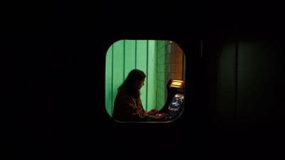 a woman sitting in front of a machine in a dark room