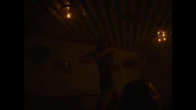 a man standing in a dark room holding a remote