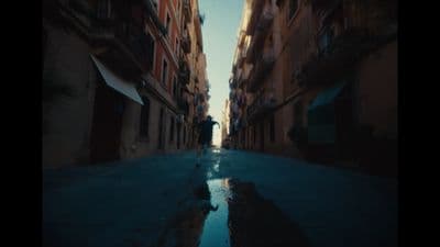a person walking down a street next to tall buildings