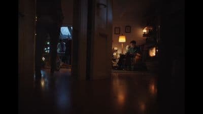 a person sitting in a chair in a dark room