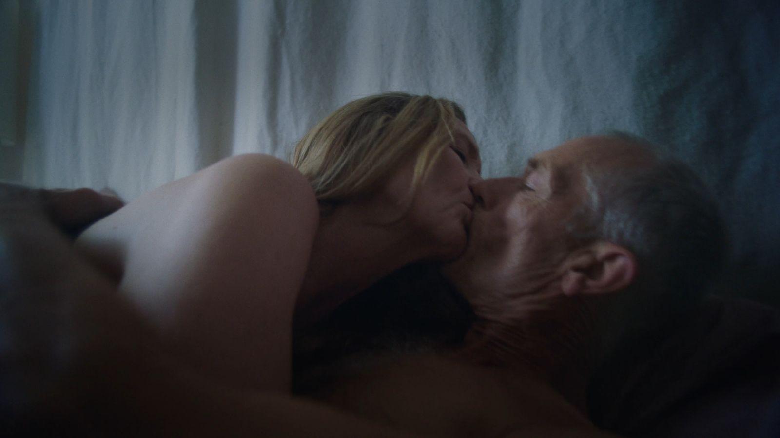 a man and a woman kissing in bed