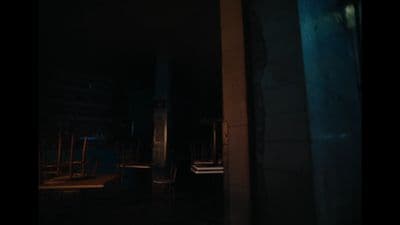 a dark room with chairs and a clock on the wall