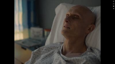 a bald man laying in a hospital bed