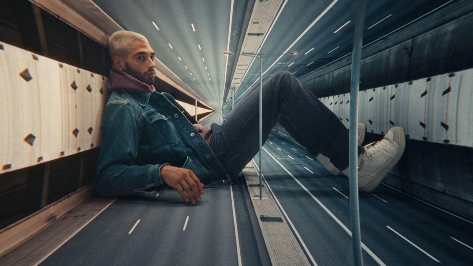 a man sitting on the ground in a tunnel