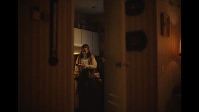 a man standing in a doorway looking at his cell phone