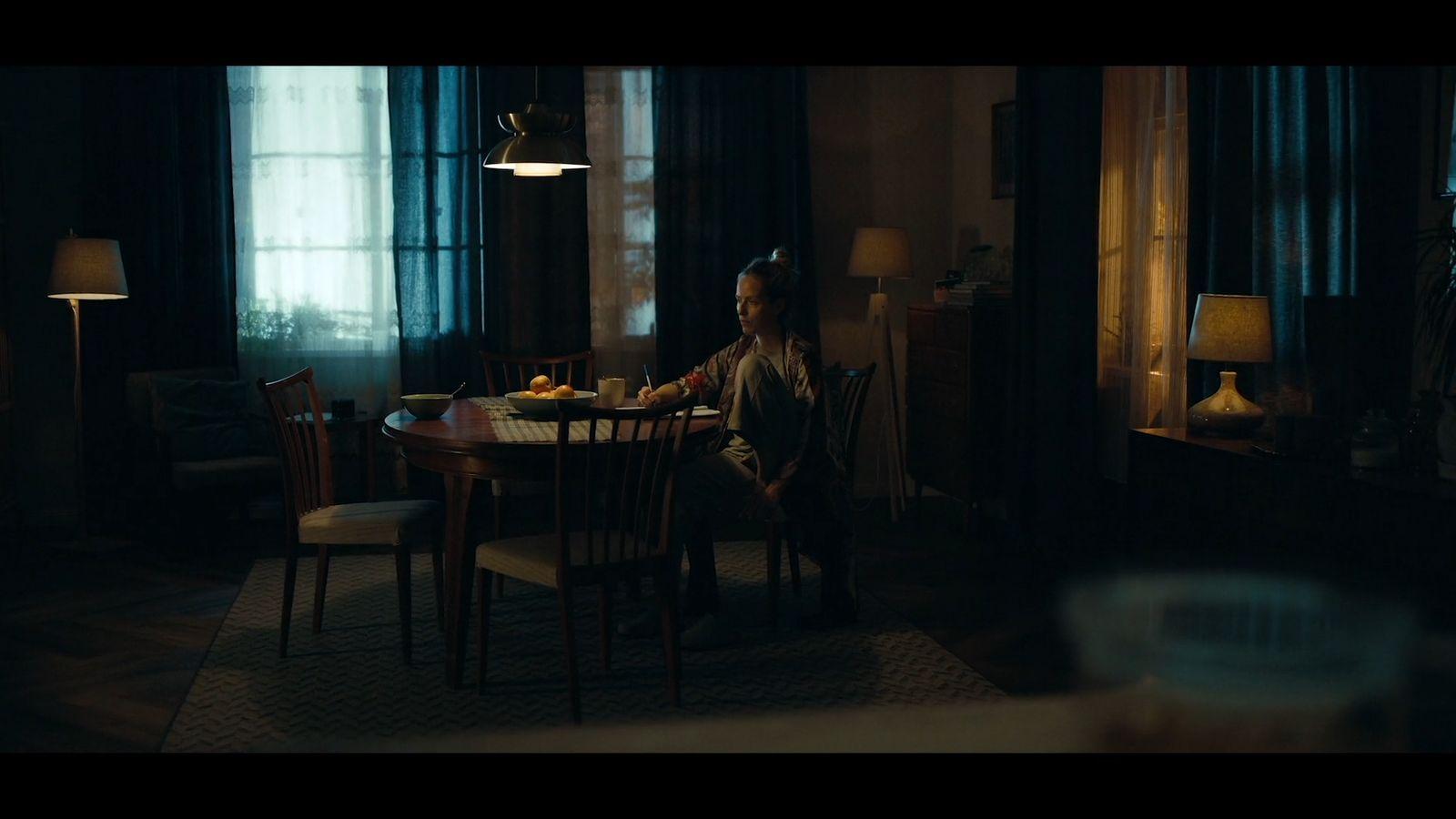 a man sitting at a table in a dark room