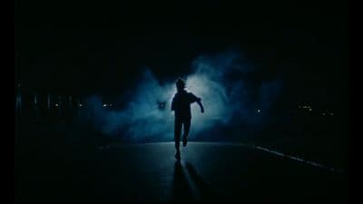 a person standing in the middle of a dark street