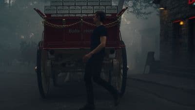 a man walking down a street next to a horse drawn carriage