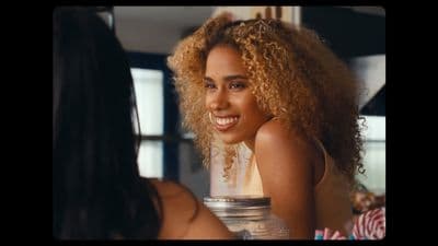 a woman with curly hair looking at another woman