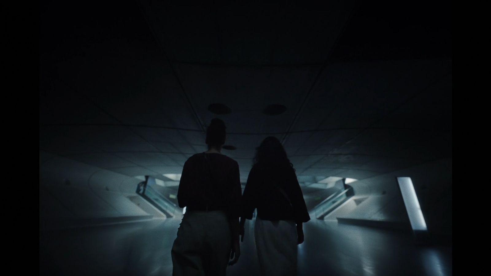 a couple of people standing in a dark room