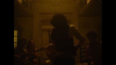 a person playing a guitar in a dark room