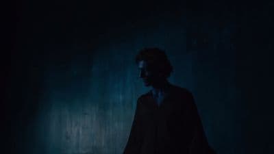 a man standing in a dark room in the dark