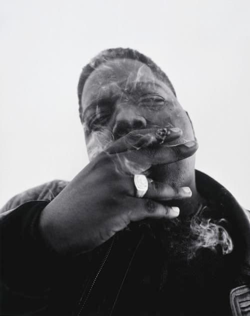 a man smoking a cigarette in a black and white photo