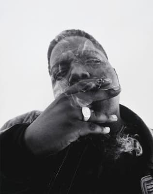 a man smoking a cigarette in a black and white photo