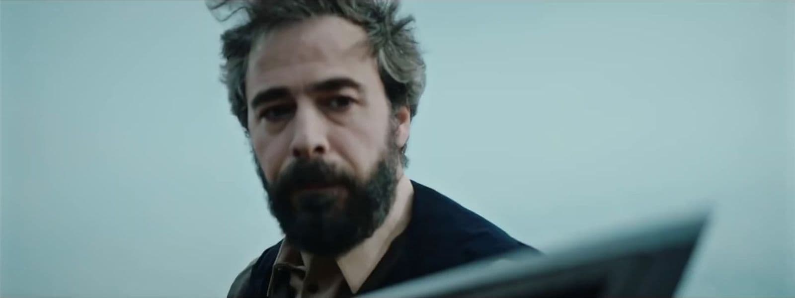 a man with a beard is staring at something