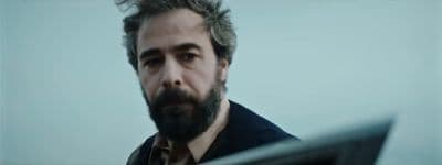 a man with a beard is staring at something