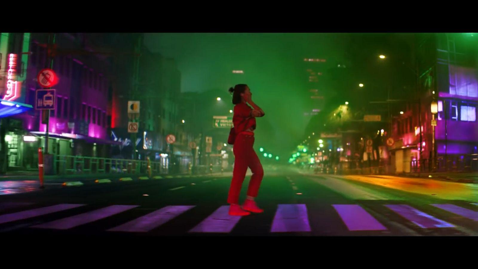 a woman in a red suit is crossing the street