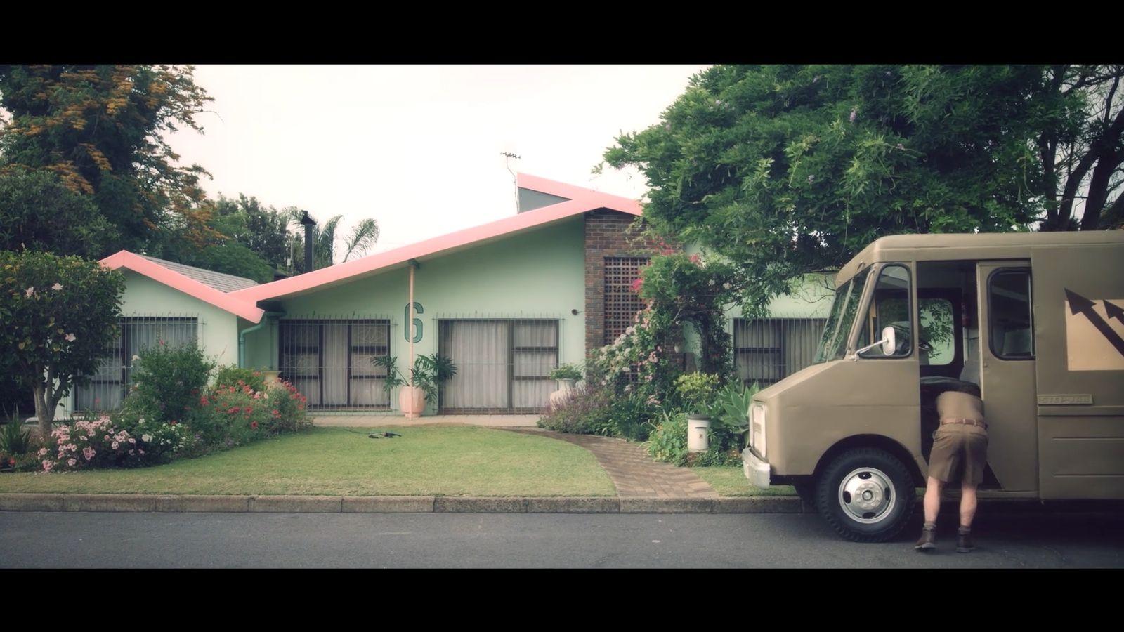 a man standing next to a moving truck in front of a house