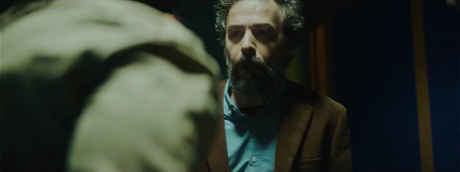 a man with a beard standing in front of a mirror