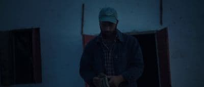 a man in a blue hat standing in a doorway