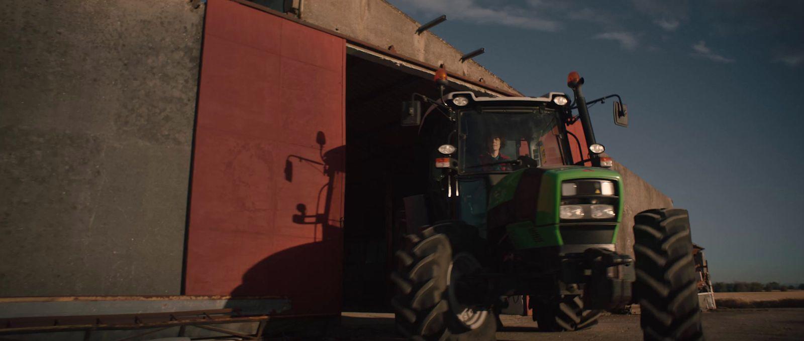a tractor parked in front of a red building