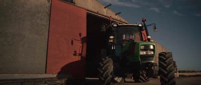 a tractor parked in front of a red building