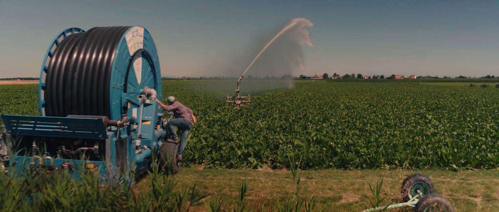 a tractor spraying water on a field of crops